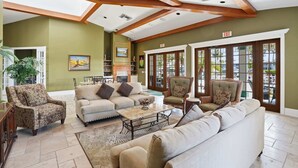 A spacious living area with a high ceiling, built-in bookshelves, and large windows. - 1315 - First-Floor Accessible Villa - Golf Views (Naples)