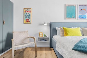 Una camera da letto con un letto, una sedia, un comodino e decorazioni alle pareti.