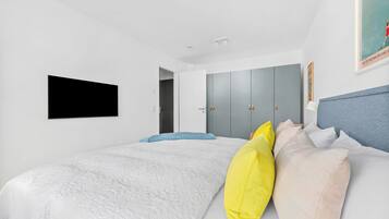Un dormitorio con una cama, un armario, una puerta y un cartel en la pared.