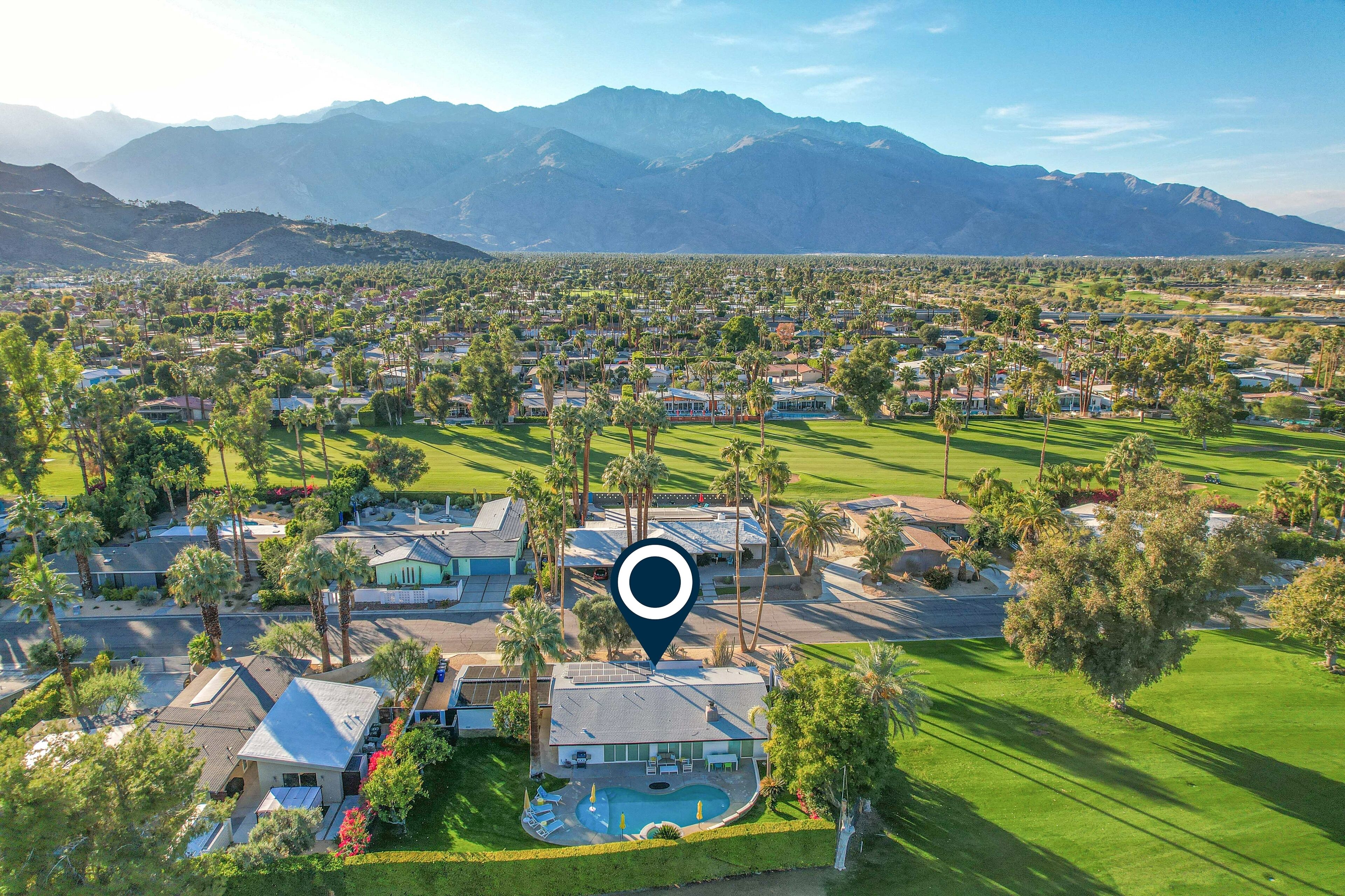 A residential area with houses, a swimming pool, and a golf course.