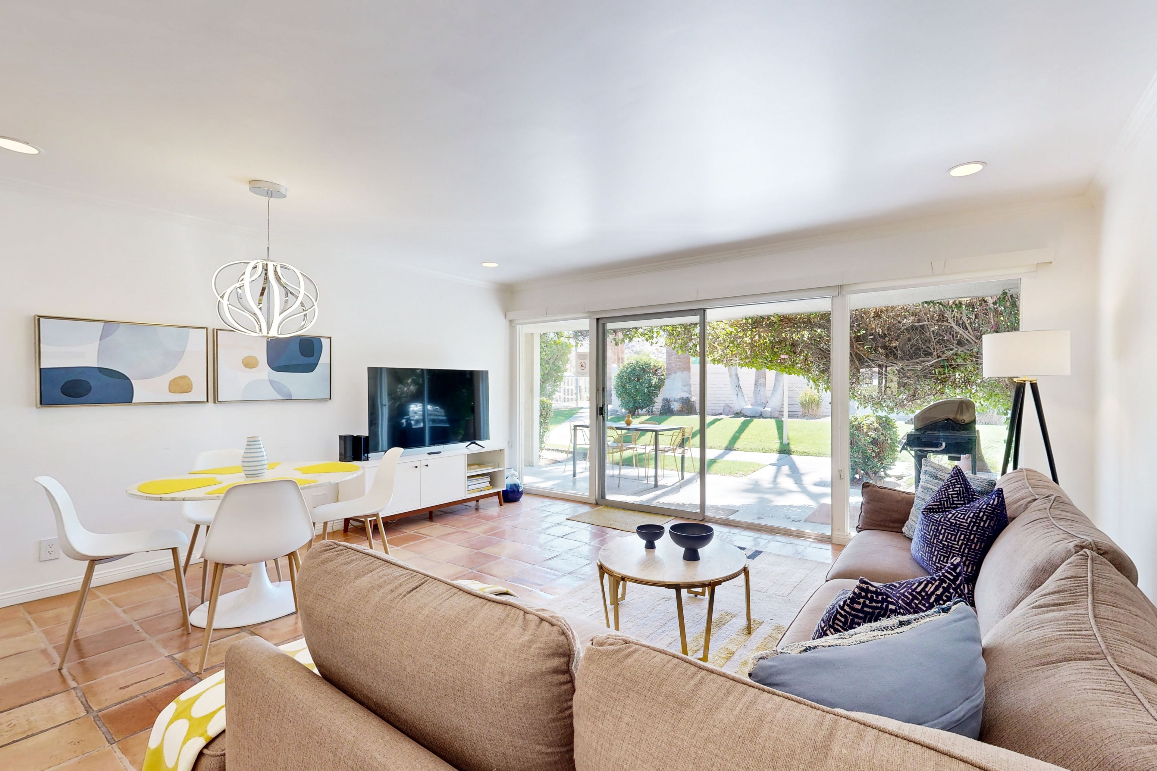 A modern living room with a sofa, coffee table, and dining area.