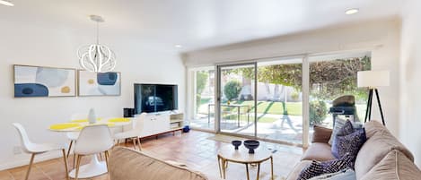 A modern living room with a sofa, coffee table, and dining area.