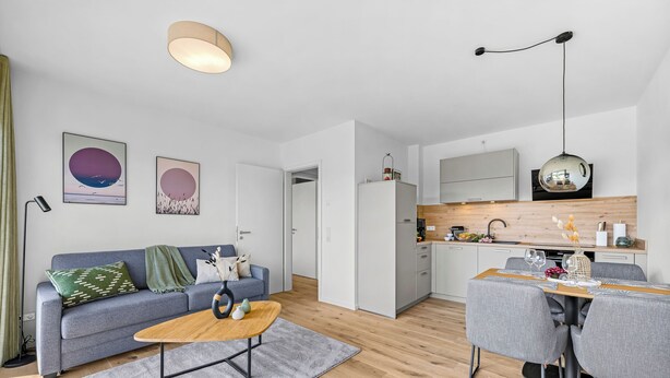 Eine moderne Wohnung mit Wohnzimmer, Essbereich und Küche.