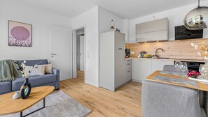 Eine moderne Wohnung mit Wohnbereich, Küche und Essplatz.