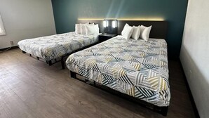 Habitació d'hotel amb dos llits, una paret d'accent color teula fosca i un disseny modern.