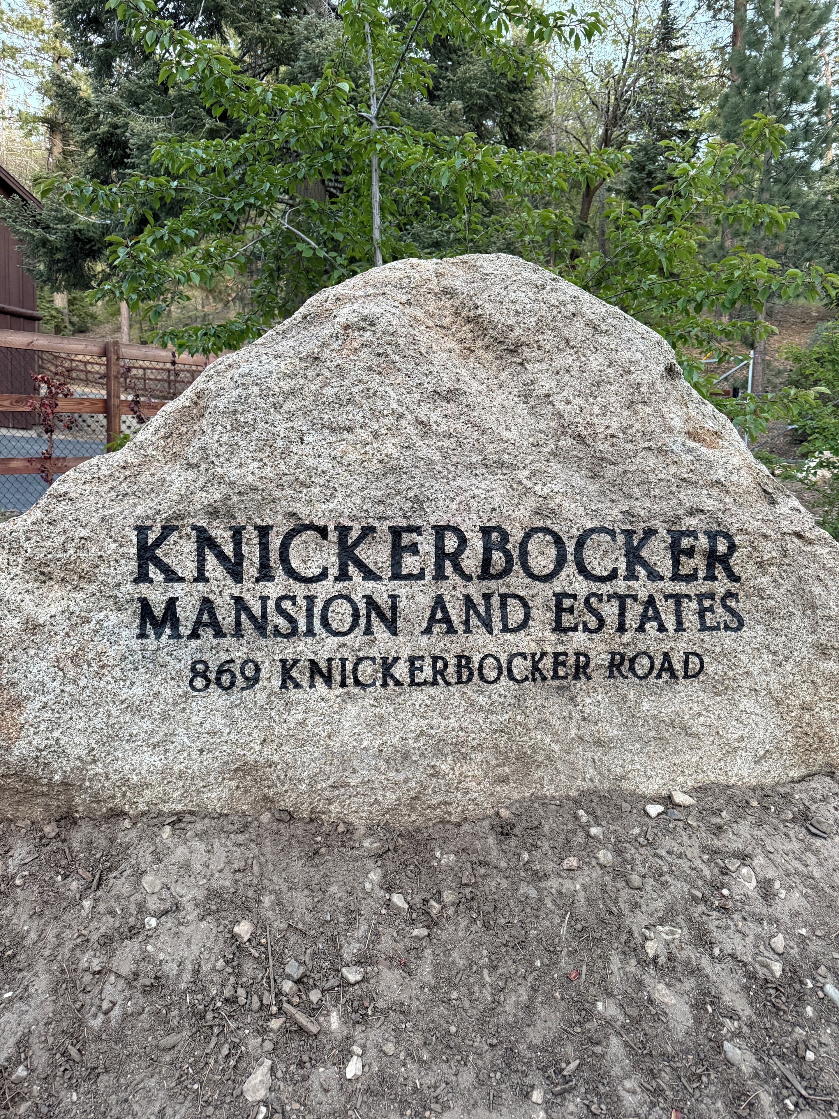 A stone monument with 'KNICKERBOCKER MANSION AND ESTATES' and '869 KNICKERBOCKER ROAD' engraved on it.