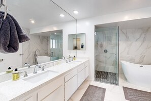 A modern bathroom with a large mirror, two sinks, a bathtub, and a glass-enclosed shower. - Entertain w/Amazing Mountain View, Private Pool/Spa, Putting Green - 2 Dogs OK (Palm Springs)