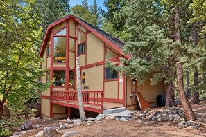 A cabin with a red exterior, large windows, and a deck. - Spacious dog-friendly cabin with creek & mountain views (Idyllwild)