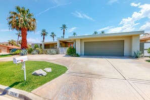 A modern two-story house with a garage, a well-maintained lawn, and palm trees. - Upscale Home in Classy Indian Wells (Indian Wells)