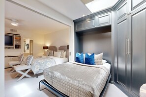 A bedroom with a large bed, two bedside tables, a wardrobe, and a television on a stand. - Lavish condo on 14th tee of Arnold Palmer course at PGA West (La Quinta)