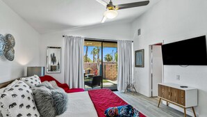 Un dormitorio con una cama, un tapete rojo, un armario de madera y un televisor.