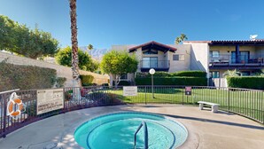 Una piscina con un puesto de salvavidas, un banco y una valla.