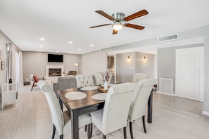 A modern dining room with a dark wooden table, beige upholstered chairs, and a ceiling fan. - Dog-friendly sunshine stay with private pool, spacious yard, central AC & W/D (Tucson)