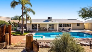 A house with a swimming pool, patio furniture, and a covered outdoor area. - Dog-friendly sunshine stay with private pool, spacious yard, central AC & W/D (Tucson)