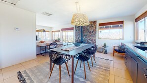 A dining area with a table, chairs, and a hanging light fixture. - Secluded hilltop home with hot tub, cowboy pool, & amazing views (Yucca Valley)
