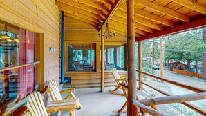 A wooden cabin with a porch, rocking chairs, and a view of the surrounding forest. - Stunning Fern Valley cabin with forest views & private hot tub - dog-friendly (Idyllwild)