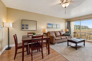 A modern living room with a dining area, a sofa, a coffee table, and a balcony with a view. - Welcoming condo with WiFi & pool - near Scottsdale Fashion Square (Scottsdale)