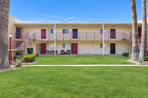 A motel with a central courtyard, a covered outdoor seating area, and a two-story structure with a flat roof. - Welcoming condo with WiFi & pool - near Scottsdale Fashion Square (Scottsdale)