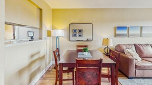 A dining area with a wooden table, chairs, a small plant, and a wall-mounted picture frame. - Welcoming condo with WiFi & pool - near Scottsdale Fashion Square (Scottsdale)