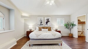 A bedroom with a large bed, two bedside tables, a ceiling fan, and a window with blinds. - Luxury home w/ private pool & optional pool heat, rooftop patio & mountain views (Fountain Hills)