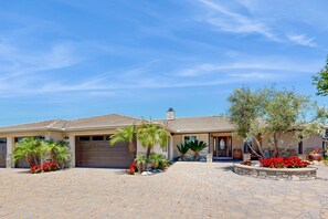A two-story house with a garage, palm trees, and a stone patio. - Private Casita Overlooking Winery | Grill, Central AC (Temecula)