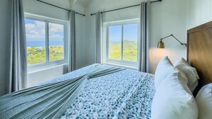 Ein Schlafzimmer mit Bett, Vorhängen, einem Fenster und einer Lampe.