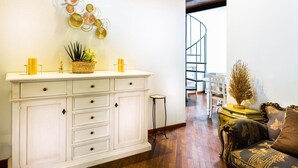 A living room with a white cabinet, a small table with candles, and a decorative plant. - Apartment "Il Campo", in the center of Siena, a few steps from Piazza del Campo (siena)