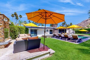 A poolside area with outdoor seating and umbrellas. - Deluxe Vista Las Palmas home w/private pool & spa - close to downtown (Palm Springs)