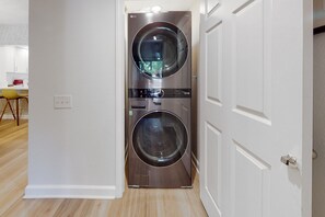 A compact, modern laundry room with two stacked front-loading washing machines. - Vibrant dog-friendly condo with hot tub, tennis court, pool, W/D, grill & patio (Palm Springs)