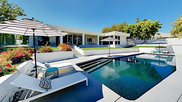 A modern outdoor pool area with a clear blue pool, lounge chairs, and umbrellas. - Mountain-View Haven with Pool, Peloton, Luxury Oasis near El Paseo (Palm Desert)