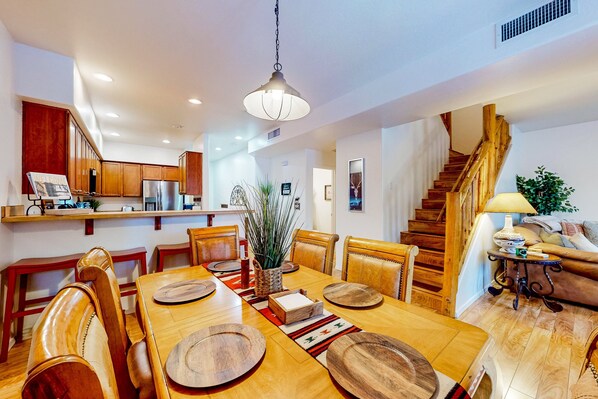 A spacious kitchen with wooden cabinets and a dining area with a large wooden table and chairs.