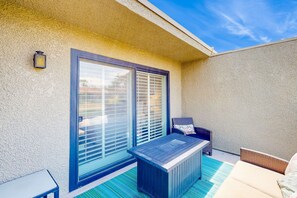 A patio with a table and chairs, a small table, and a bench. - Palm Desert Resorter | New Furnishings | 20 Pools, Championship Golf (Palm Desert)