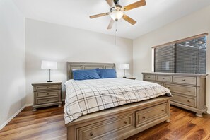 A bedroom with a bed, nightstands, a dresser, a ceiling fan, and a window with blinds. - Peaceful retreat with covered porch, washer/dryer - golf/hiking (Pinetop)