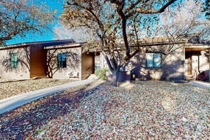 A residential property with a covered patio, a tree, and a driveway. - Sunlit dog-friendly home with central AC, deck, & fireplace - near golf & trails (Flagstaff)