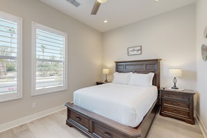 A bedroom with a large bed, two bedside tables with lamps, a nightstand, and a window with blinds. - The Dream Weaver | House in La Quinta with a private pool and hot tub (La Quinta)