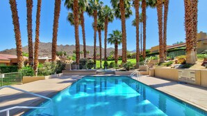 A swimming pool surrounded by tall palm trees, with a mountain in the background. - Cozy Dog-Friendly Condo, Shared Pool/Hot Tub, Near Golf Courses & National Park (Palm Desert)