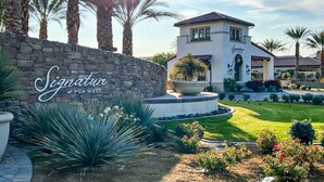 Un bâtiment doté d’un mur en pierre et d’une enseigne sur laquelle on peut lire : « Signature at PGA West ».