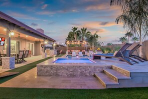 Un jardin avec une piscine, du mobilier d’extérieur et un espace patio.