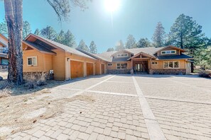 A two-story wooden house with a covered driveway and a stone wall. - Elegant Flagstaff Golf Club estate with exquisite views, fireplace (Flagstaff)