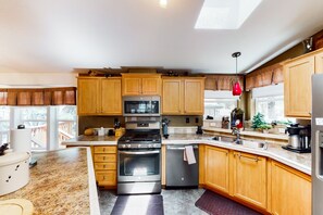 A kitchen with wooden cabinets, stainless steel appliances, a built-in oven, and a dishwasher.
