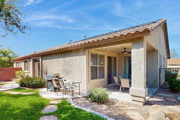 A single-story house with a patio area, a barbecue grill, and a covered seating area. - Home in gated community with private pool near sports - great location in Peoria (Peoria)