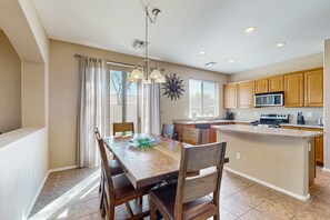 A spacious kitchen with wooden cabinets, a central island, and a dining area with a wooden table and chairs. - Home in gated community with private pool near sports - great location in Peoria (Peoria)