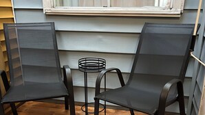 A wooden deck with two black chairs and a small round table. - Downtown Digs (St. John's)