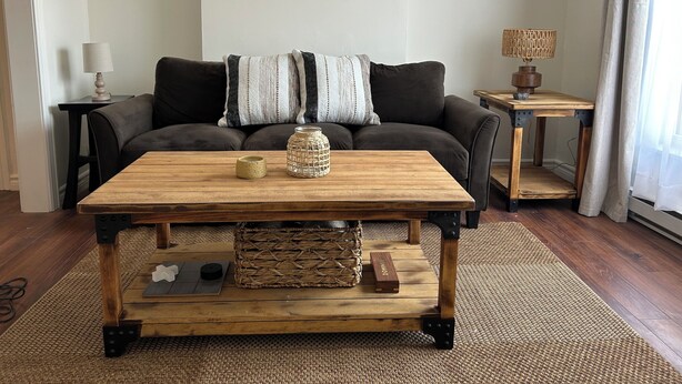 A living room with a wooden coffee table, a woven basket, and a small wooden block. - Downtown Digs (St. John's)