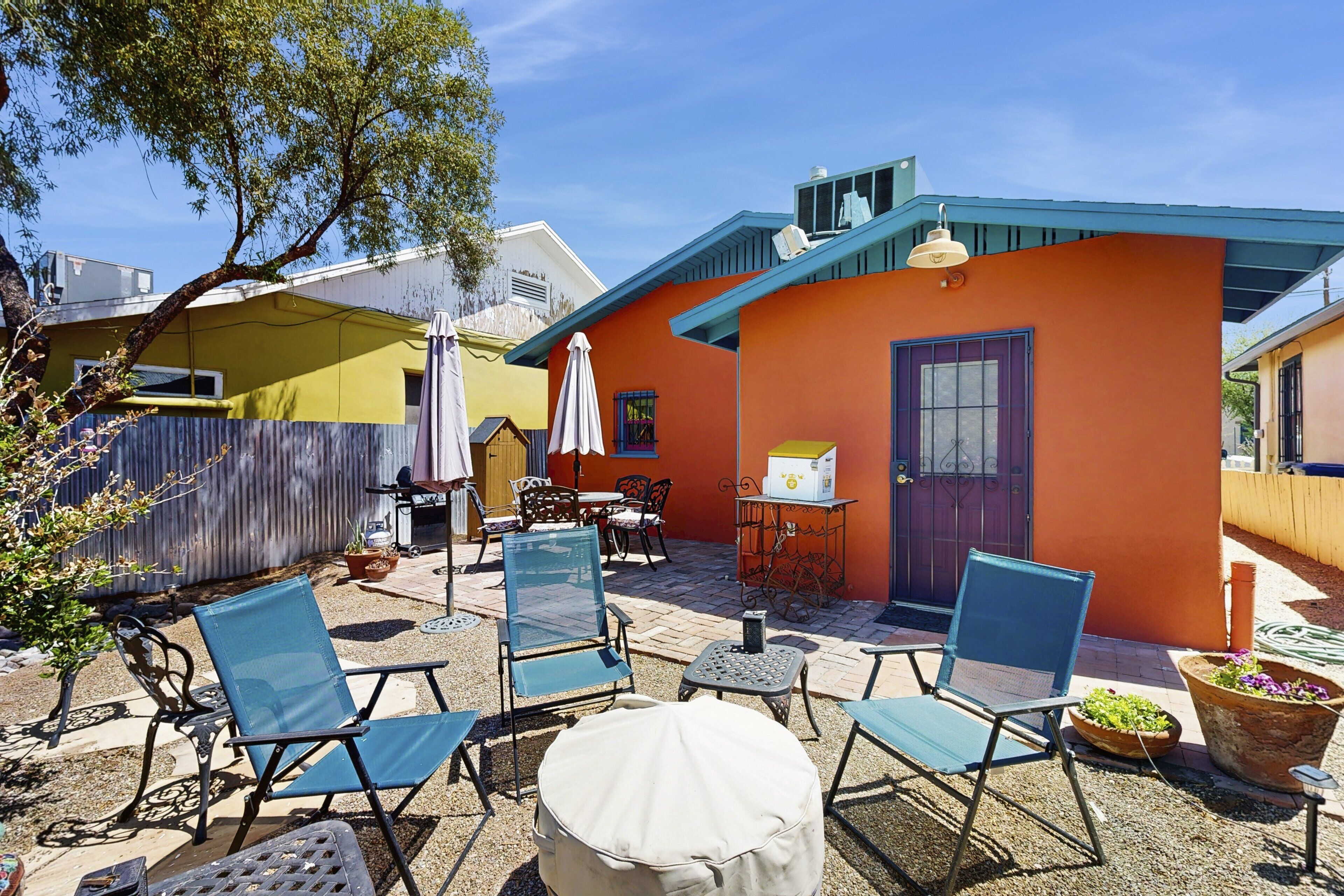 Eine Terrasse mit Sitzgelegenheit, einem kleinen Tisch und einem Blumentopf.
