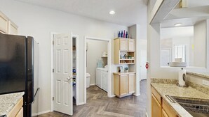 A kitchen with a refrigerator, cabinets, and a countertop. - Beautiful first-floor condo with pool, hot tub, & full kitchen - near hiking (Oro Valley)