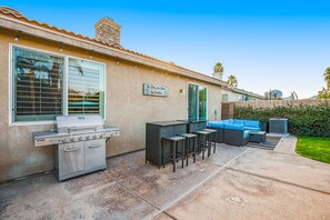 A patio with a grill, outdoor seating, and a sign that reads "No Shoes, No Sticks, No Doubt." - Dazzling retreat w/ a pool, grill, firepit, game room, & W/D - snowbird friendly (Indio)