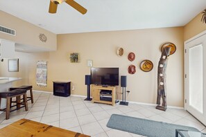 A living room with a TV, wooden furniture, and decorative items on the wall. - Dog-friendly Sedona town home, walking distance to shops & surrounded by beauty (Sedona)