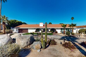 A house with a red-tiled roof, large rocks, and cacti in the front yard. - Renovated dog-friendly mtn-view home with private pool, large backyard, grill (Palm Desert)