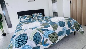 A bedroom with a bed, a potted plant, and a wardrobe. - Accommodation - Communay guest house. (Communay)